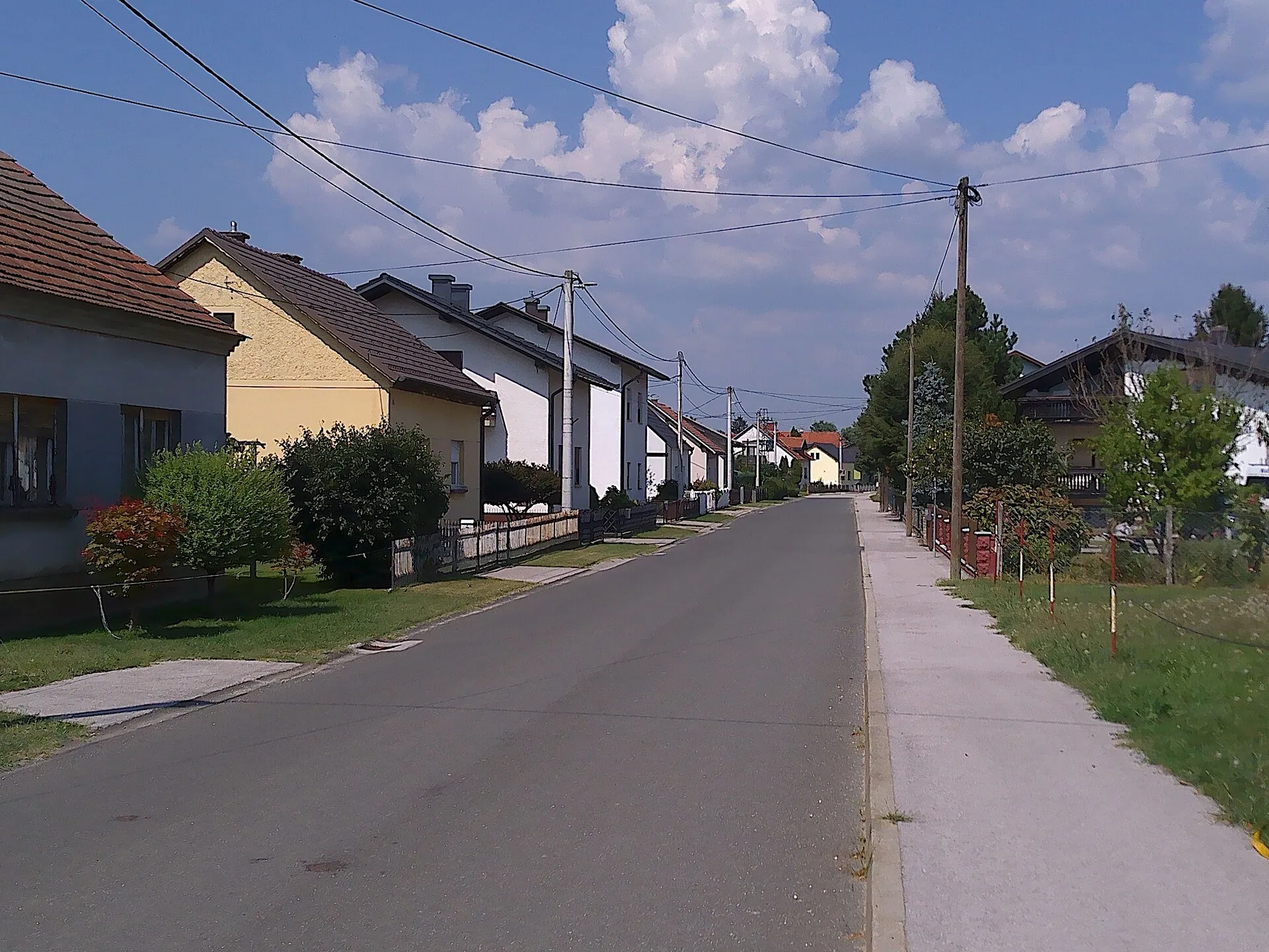 Dorfstraße in Bakovci mit Einfamilienhäusern und Vorgärten
