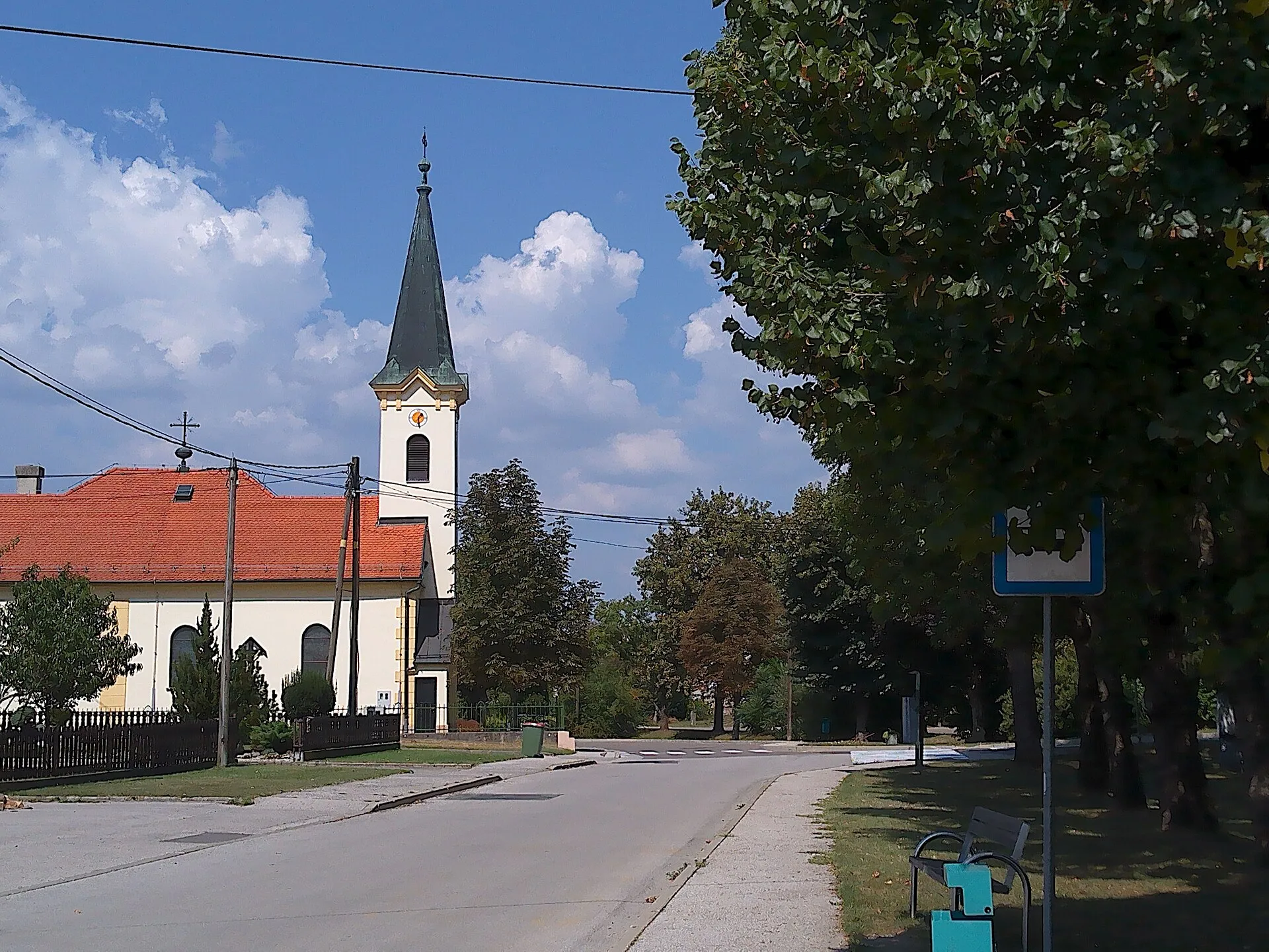 Straße in Bakovci mit der Pfarrkirche St. Anna und alten Platanen
